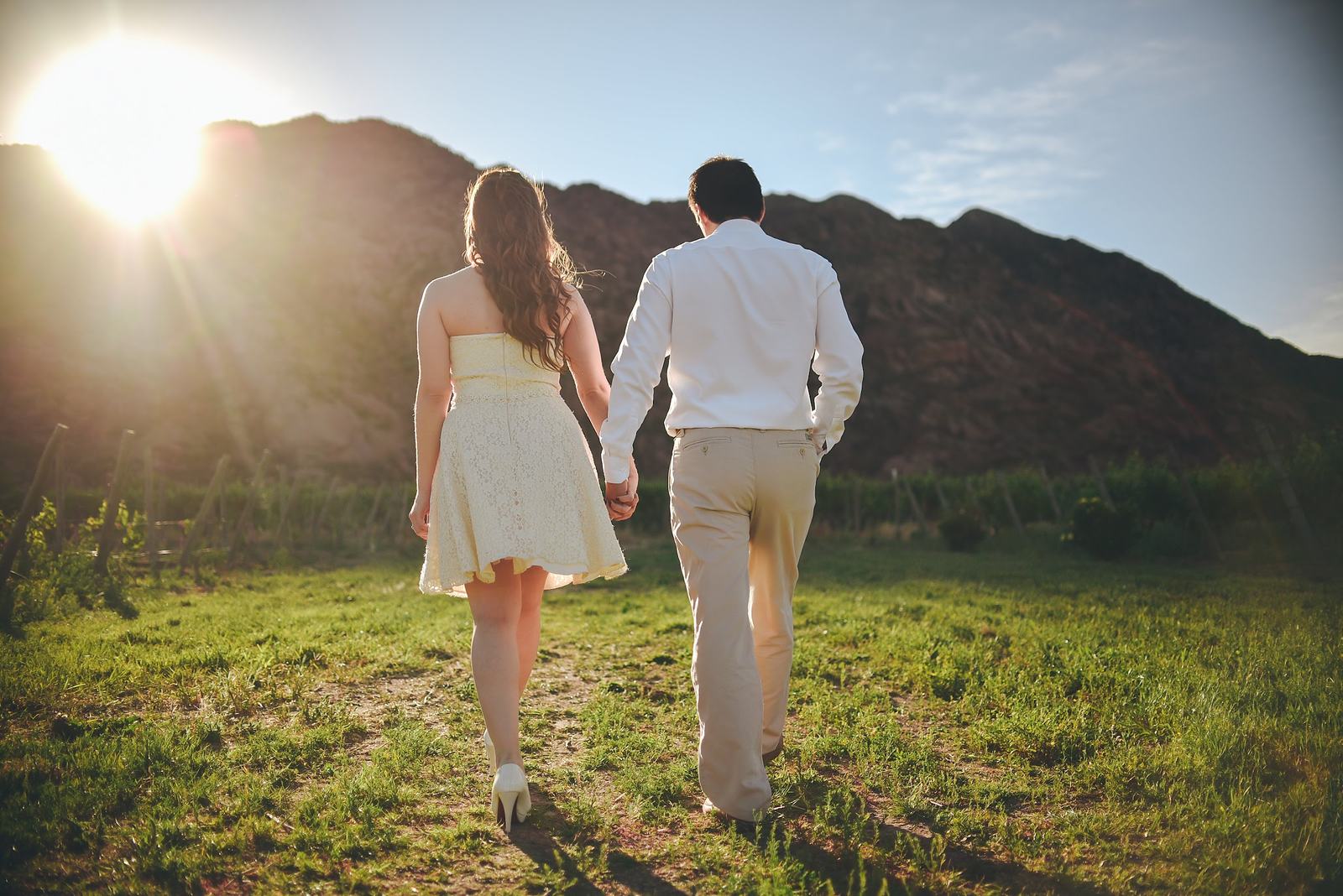 Pareja caminando hacia las montañas al atardecer